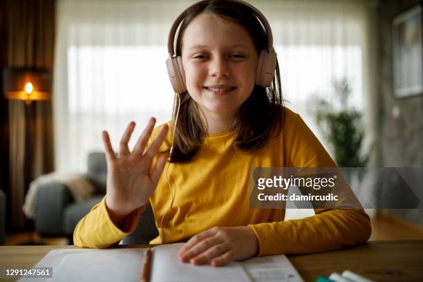 porträtt av leende ung skolflicka med hörlurar som går till online skolklass hemifrån - girl camera bildbanksfoton och bilder