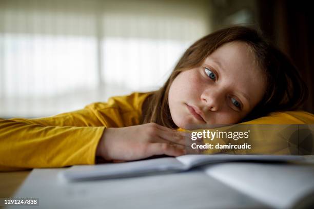 bored young school girl studying at home - adhd child imagens e fotografias de stock