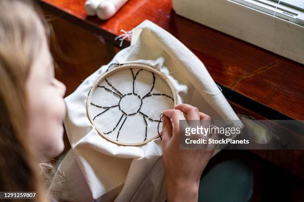 young girl doing some needlework - embroidery stock pictures, royalty-free photos & images