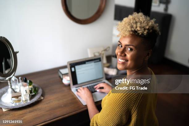 portrait of a woman using laptop at home - take control imagens e fotografias de stock