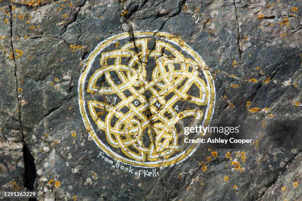 an artwork of the book of kells on a rock on iona, off mull, scotland, uk. - book of kells stock pictures, royalty-free photos & images