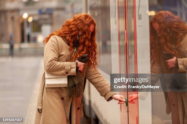 close up of teenage girl commuter pushing the button to open the doors of the train. she's wearing a face mask - door close button imagens e fotografias de stock