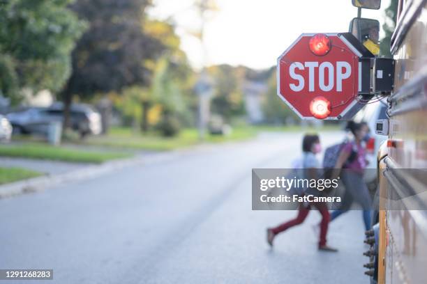 het bushalteteken van de school voor kinderen om over te gaan - bus pass stockfoto's en -beelden