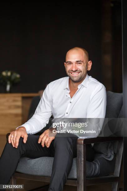 portrait of the happy man in the chair - man muscular build stock pictures, royalty-free photos & images