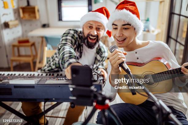 father and son singing and playing music - acoustic christmas stock pictures, royalty-free photos & images