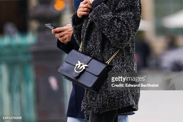 Passerby wears a wool coat, a black leather JW Anderson bag, on December 13, 2020 in Paris, France.