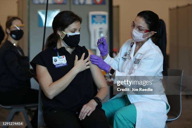 Diana Carolina, a pharmacist at Memorial Healthcare System, receives a Pfizer-BioNtech Covid-19 vaccine from Monica Puga, ARNP at Memorial Healthcare...