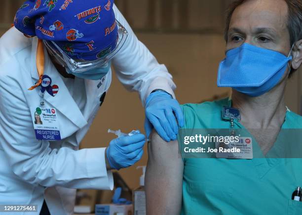 Dan Lacey, Directeor of Clinical Ops and Reg. Affairs, Memorial Healthcare System, receives a Pfizer-BioNtech Covid-19 vaccine from Cheryl...