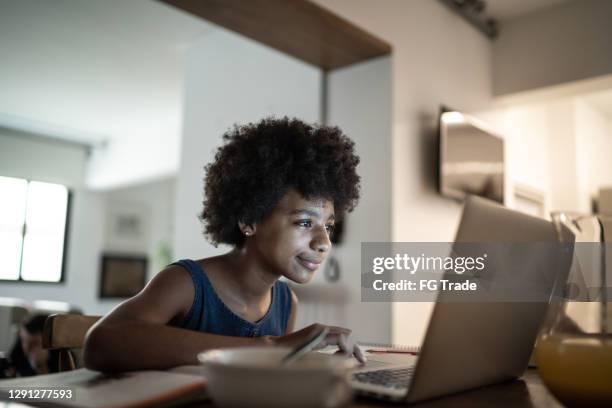 teenager-mädchen beobachten video-klasse auf laptop zu hause - black girl with computer stock-fotos und bilder