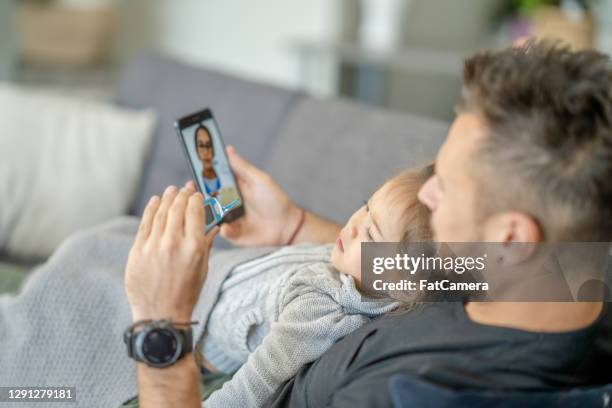 telemedicine call between doctor and father - telemedicine visit stock pictures, royalty-free photos & images