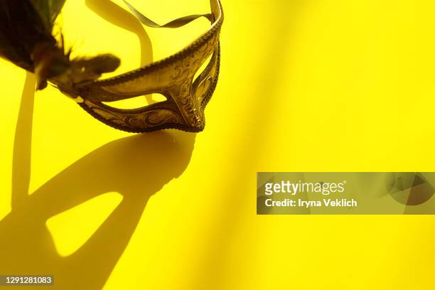 carnival venetian mask with shadows on yellow background on sunlight. - masquerade mask stockfoto's en -beelden