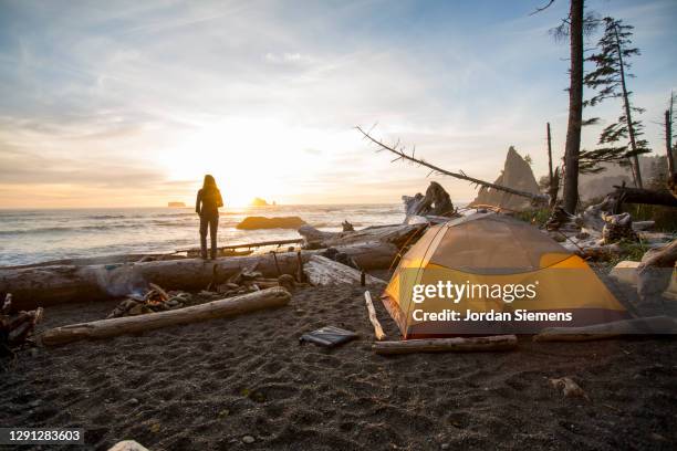 a woman backpacking and camping along washintons remote coast. - rialto beach stock pictures, royalty-free photos & images