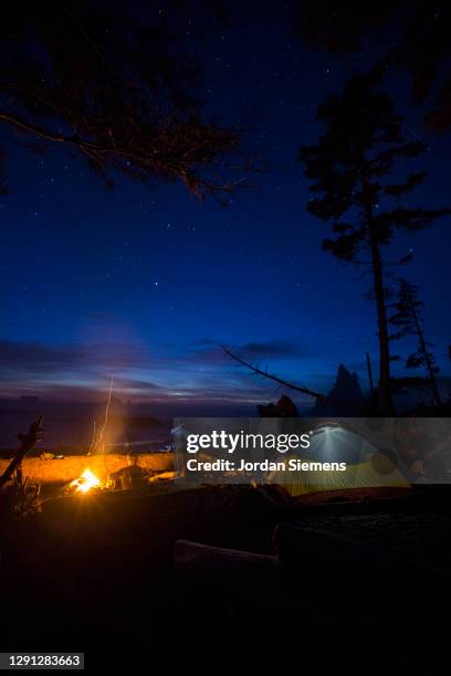 a woman backpacking and camping along washintons remote coast. - rialto beach fotografías e imágenes de stock