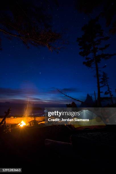 a woman backpacking and camping along washintons remote coast. - rialto beach stock pictures, royalty-free photos & images