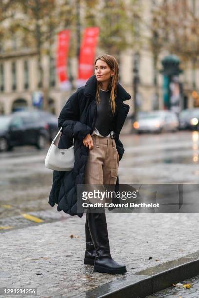 Natalia Verza aka "Mascarada Paris" wears a white t-shirt, a black bustier from Loewe, beige cargo short pants from Chloe, black knee high leather...