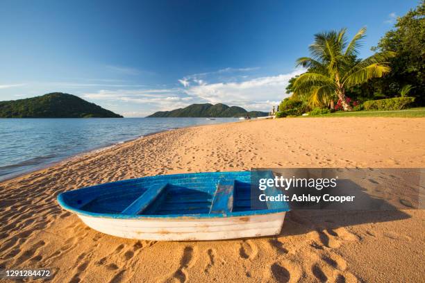 a boat on a beach at cape maclear on the shores of lake malawi, malawi, africa. - lake malawi stock pictures, royalty-free photos & images