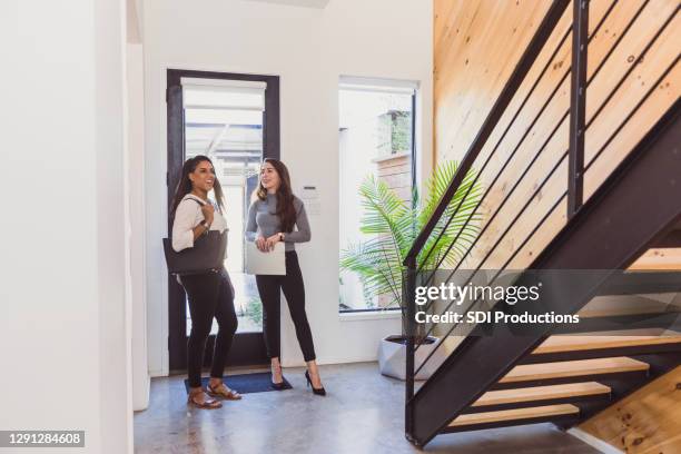 medio volwassen vrouw glimlacht bij mooie ingang aan nieuw huis - family tree stockfoto's en -beelden