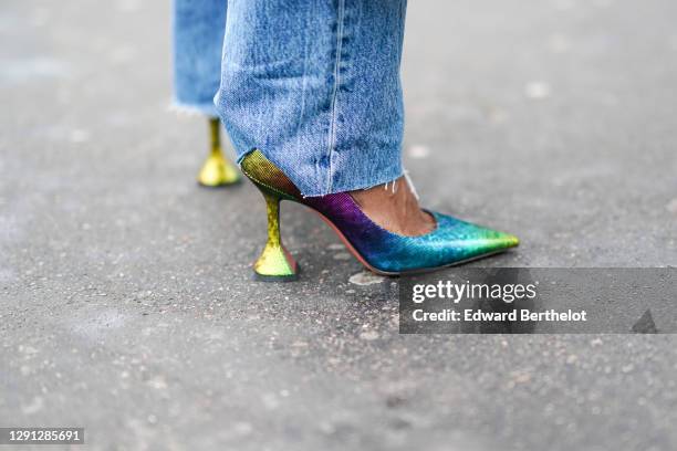 Carrole Sagba wears Zara blue jeans, shiny glittering neon blue and green pointy shoes with kitten heels from Amina Muaddi, on December 12, 2020 in...