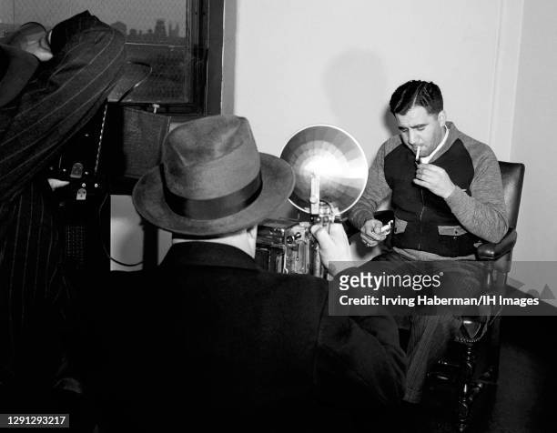 The most feared hitman for Murder, Inc, Abe "Kid Twist" Reles , lights his cigarette while sitting at the District Attorney's office in police...