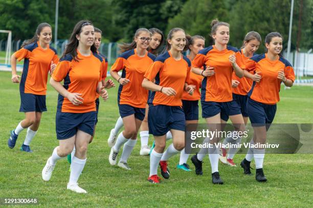 time de futebol feminino correndo para o aquecimento - high school football - fotografias e filmes do acervo