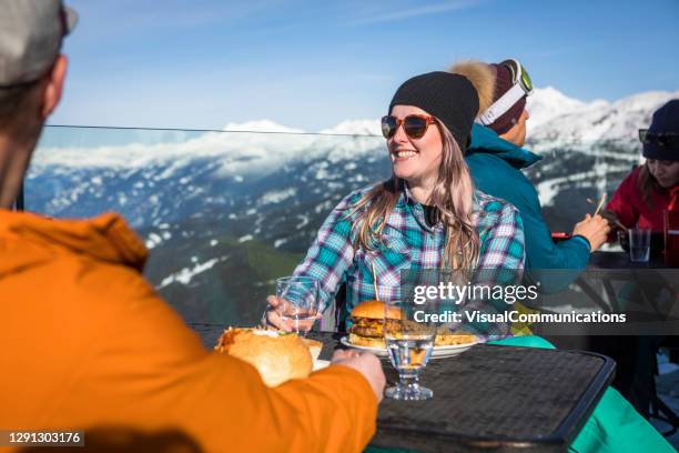 group of friends enjoying apres-ski at top of whistler mountain. - terrace british columbia stock pictures, royalty-free photos & images