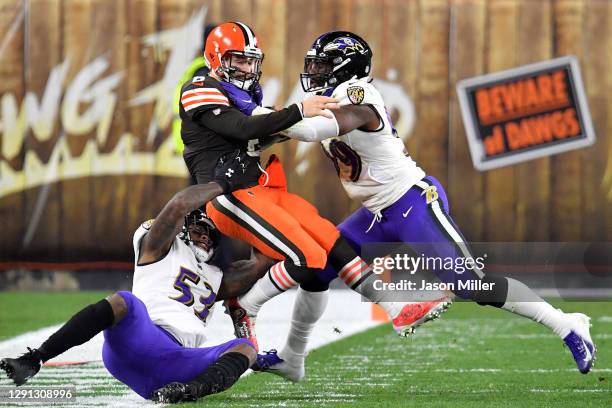 Baker Mayfield of the Cleveland Browns is tackled by Jihad Ward and Matt Judon of the Baltimore Ravens during the first quarter in the game at...