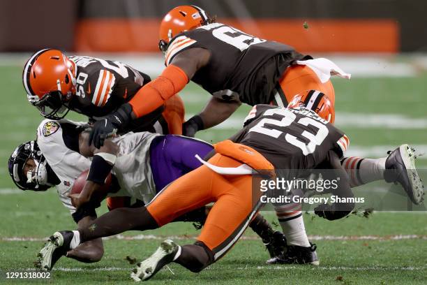 Jacob Phillips, Andrew Sendejo and Larry Ogunjobi of the Cleveland Browns force a tackle during the third quarter in the game against the Baltimore...