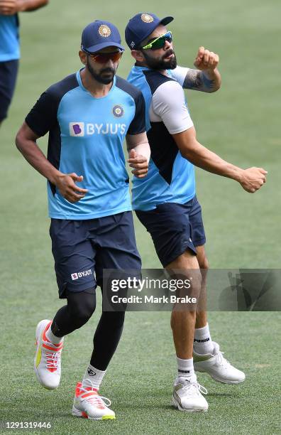 Virat Kohli of India bumps KL Rahul vice captain of India during a warm-up lap of an Indian Nets Session at Adelaide Oval on December 15, 2020 in...