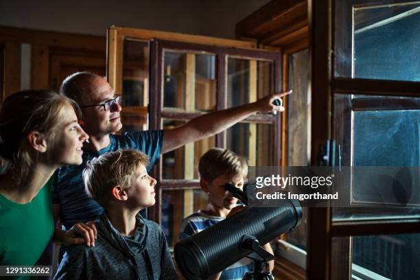 padre e figli che osservano la luna e le stelle - astronomia foto e immagini stock