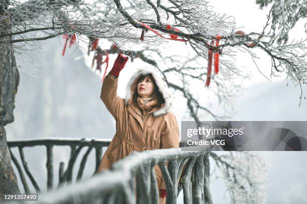 Tourist enjoys rime scenery after snow at the Tianmenshan scenic area on December 14, 2020 in Zhangjiajie, Hunan Province of China.