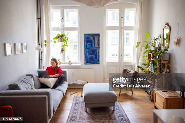 woman working at home using laptop - appartement salon stockfoto's en -beelden