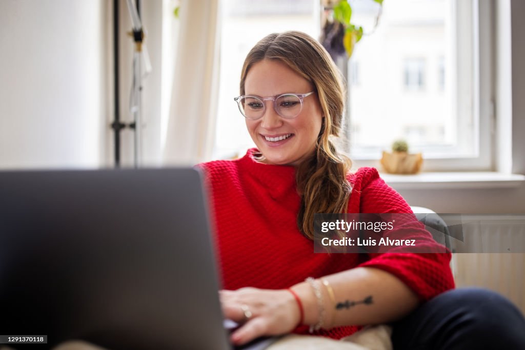 Happy woman working on laptop at home