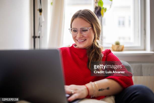 happy woman working on laptop at home - tre quarti foto e immagini stock