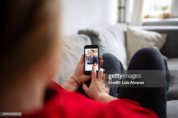 woman using dating app on mobile phone - online romance stock pictures, royalty-free photos & images