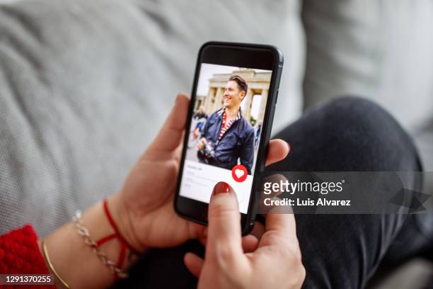 female using a dating app on smart phone - applicazione mobile foto e immagini stock