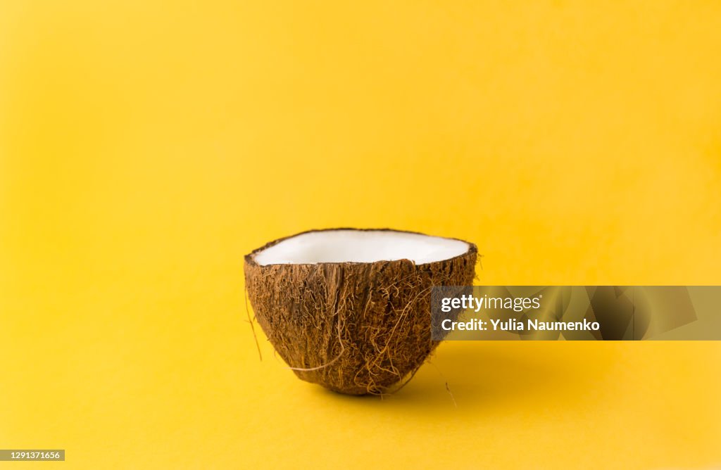 Coconut on yellow backgroun. Summer concept.