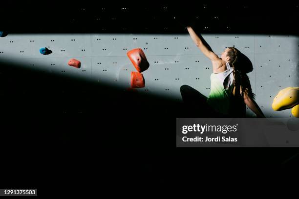 climber woman climbing a wall - bouldern indoor stock pictures, royalty-free photos & images