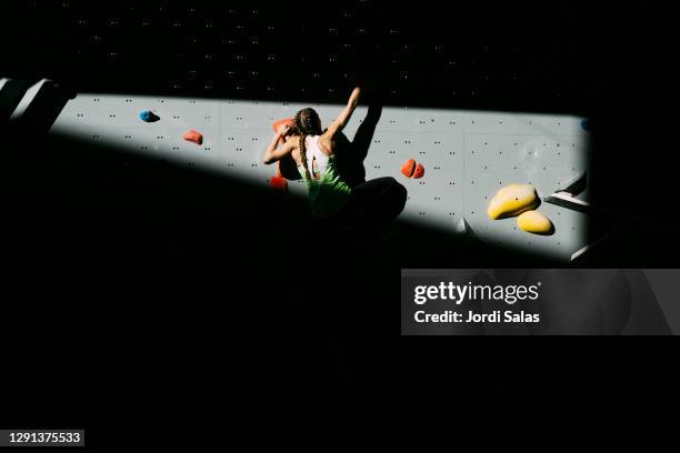 climber woman climbing a wall - bouldering stock pictures, royalty-free photos & images