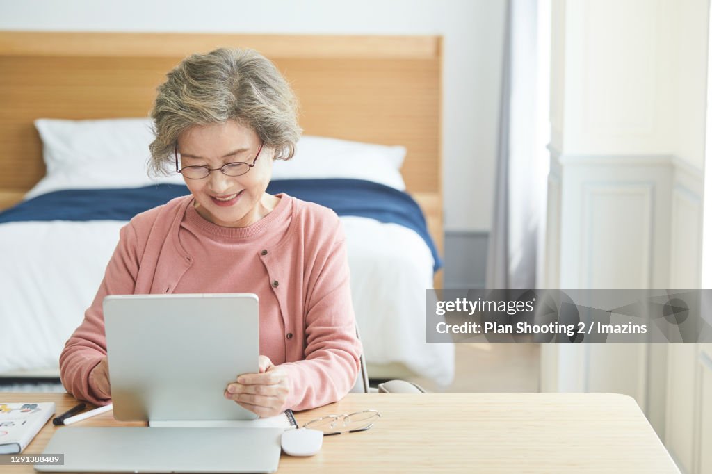 An Elder Woman Studying with Digital Tablet