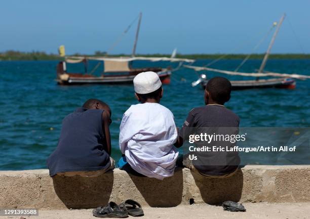 Three muslim boys chatting alongside the dockside, Lamu County, Lamu, Kenya on March 1, 2011 in Lamu, Kenya.