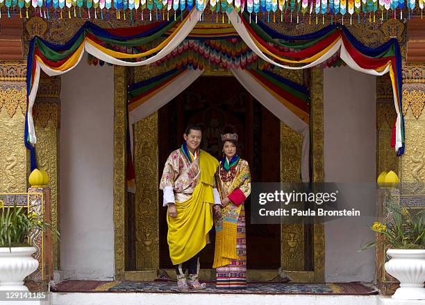 His majesty King Jigme Khesar Namgyel Wangchuck holds his Raven crown as he and the Queen Jetsun Pema walk out after their marriage ceremony is...