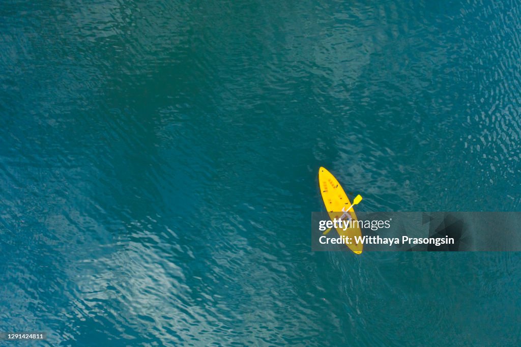 Man in a canoe over turquoise, tropical waters