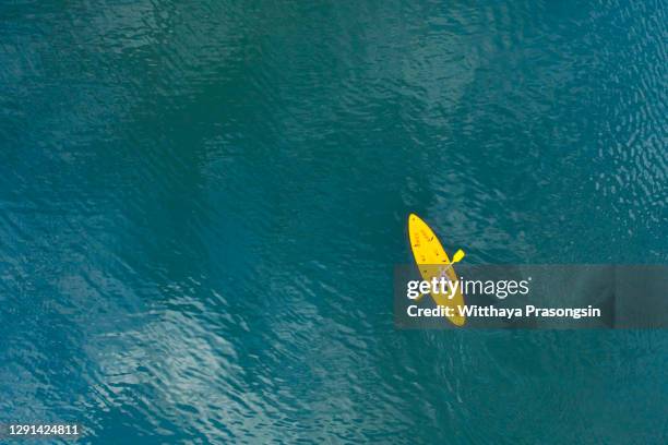 man in a canoe over turquoise, tropical waters - kayak barco de remos fotografías e imágenes de stock