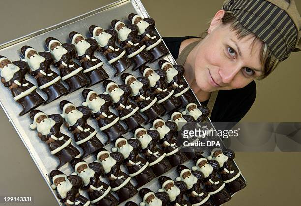 Employee Katja Schumann of chocolate manufacturer Confiserie Felicitas GmbH in Hornow, eastern Germany, shows chocolate made Santa Claus figures on...