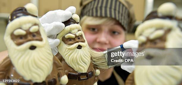 Employee Katja Schumann of chocolate manufacturer Confiserie Felicitas GmbH in Hornow, eastern Germany, works on a chocolate made Santa Claus figure...