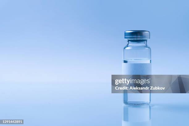a glass medical bottle or ampoule with a vaccine for covid-19 or for colds and flu on a white background. the concept of treatment and prevention of the spread of infection, virus and pneumonia. - medicinflaska bildbanksfoton och bilder