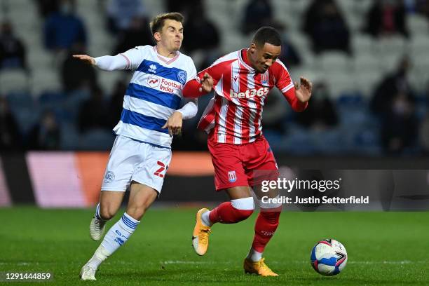 Tom Ince of Stoke City is challenged by Tom Carroll of Queens Park Rangers during the Sky Bet Championship match between Queens Park Rangers and...