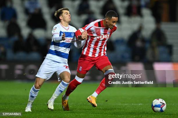 Tom Ince of Stoke City is challenged by Tom Carroll of Queens Park Rangers during the Sky Bet Championship match between Queens Park Rangers and...