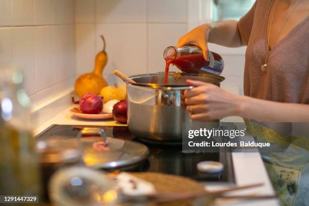 woman dyeing fabrics in the kitchen - glaskeramik stock-fotos und bilder