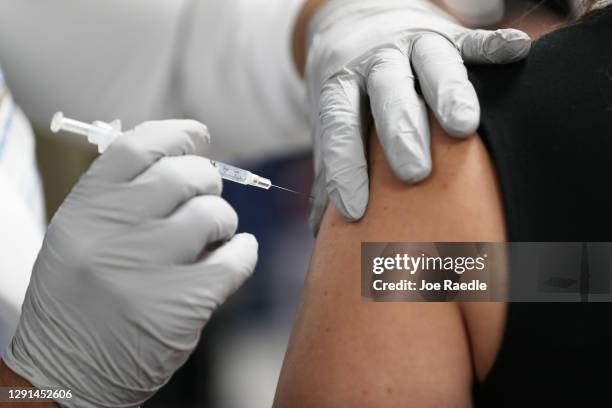 Healthcare worker at the Jackson Health Systems receives a Pfizer-BioNtech Covid-19 vaccine from Susana Flores Villamil, RN from Jackson Health...